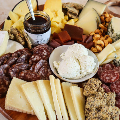 up close image of a cheese board with 7 cheeses and meat and pairings