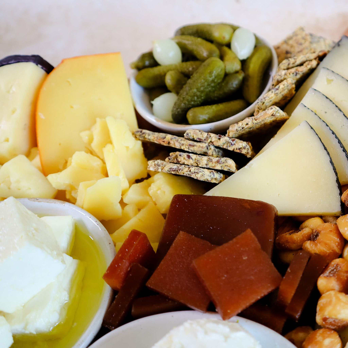 Up close image of three cheeses and pairings on a board