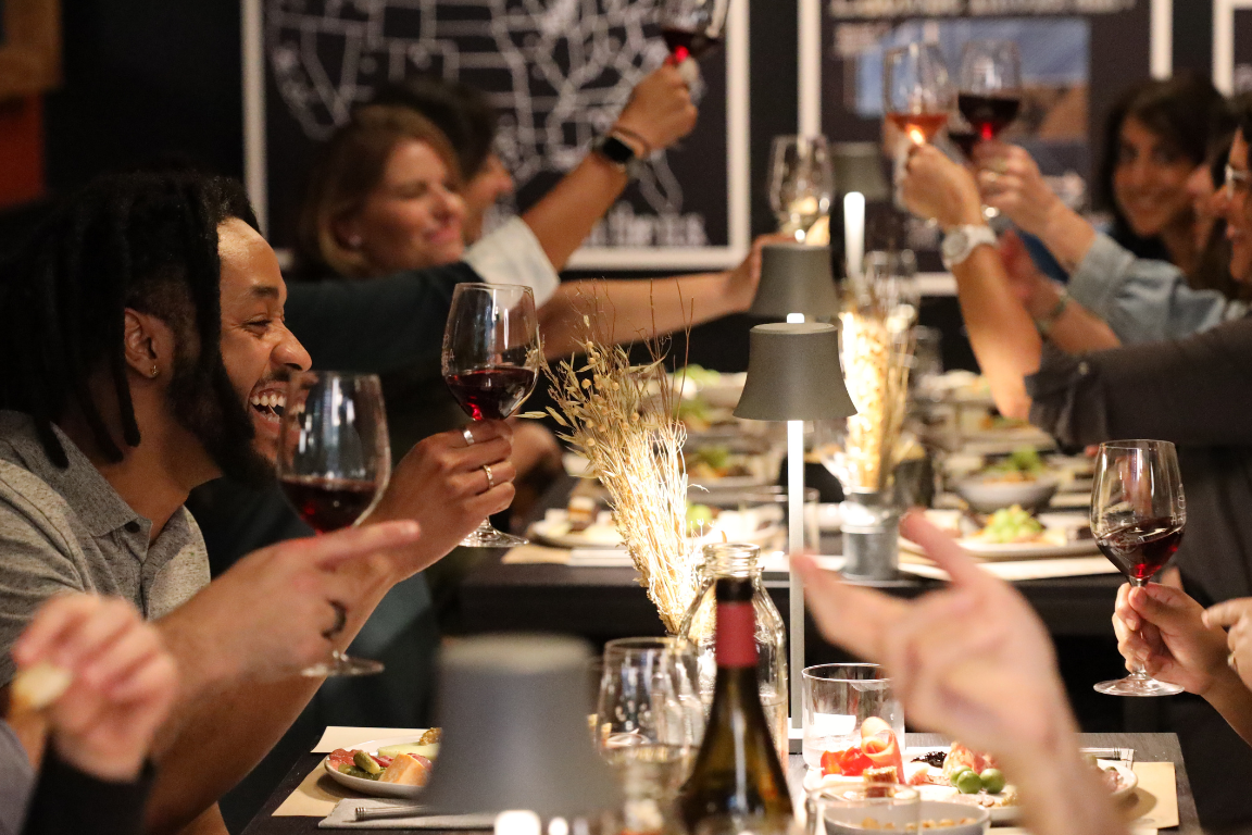 People raising a toast at Antonelli's Tasting Room during a Cheese Tasting Experience