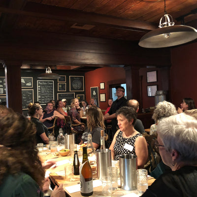 dark room filled with happy guests eating cheese