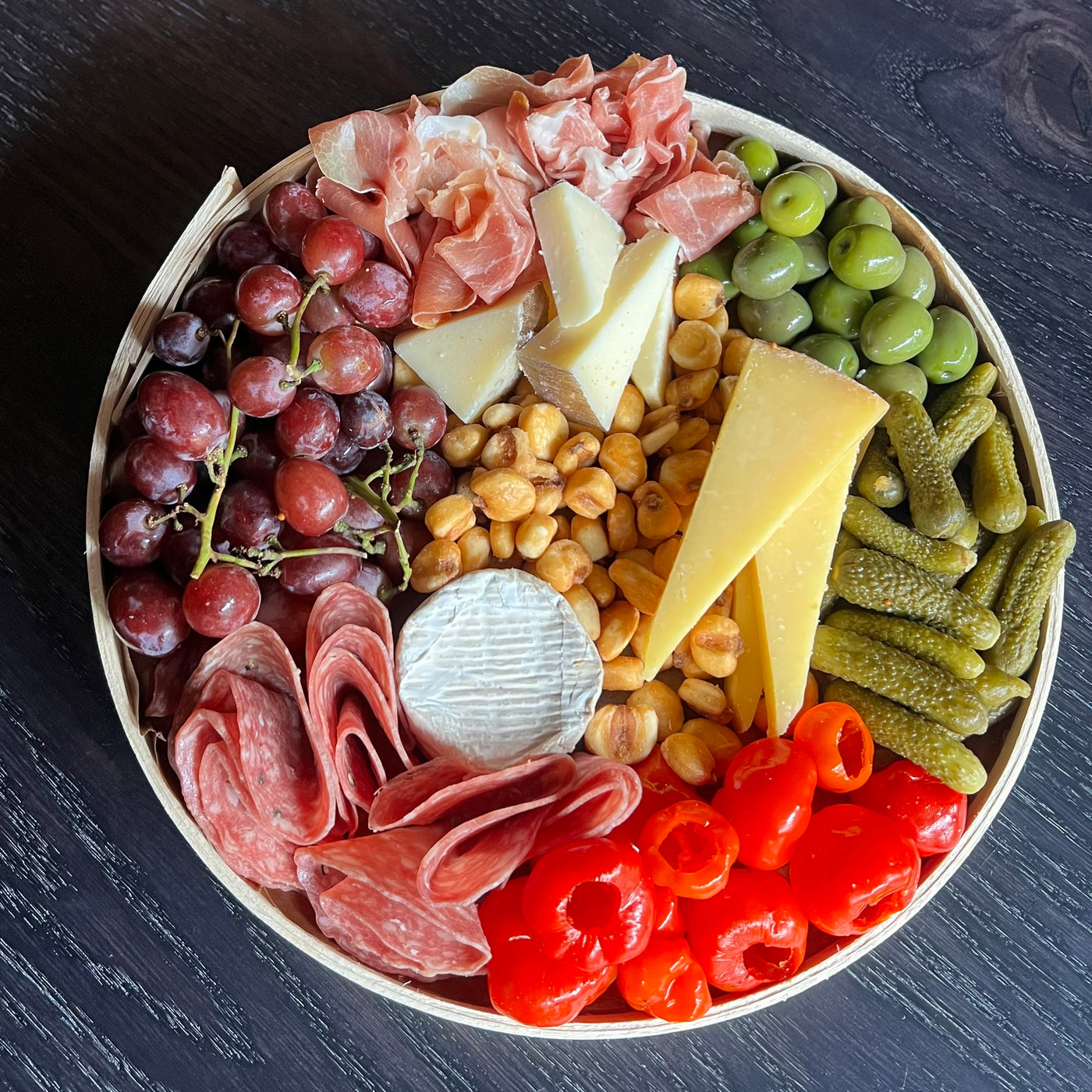 Cheese board with three cheeses and olives and meat