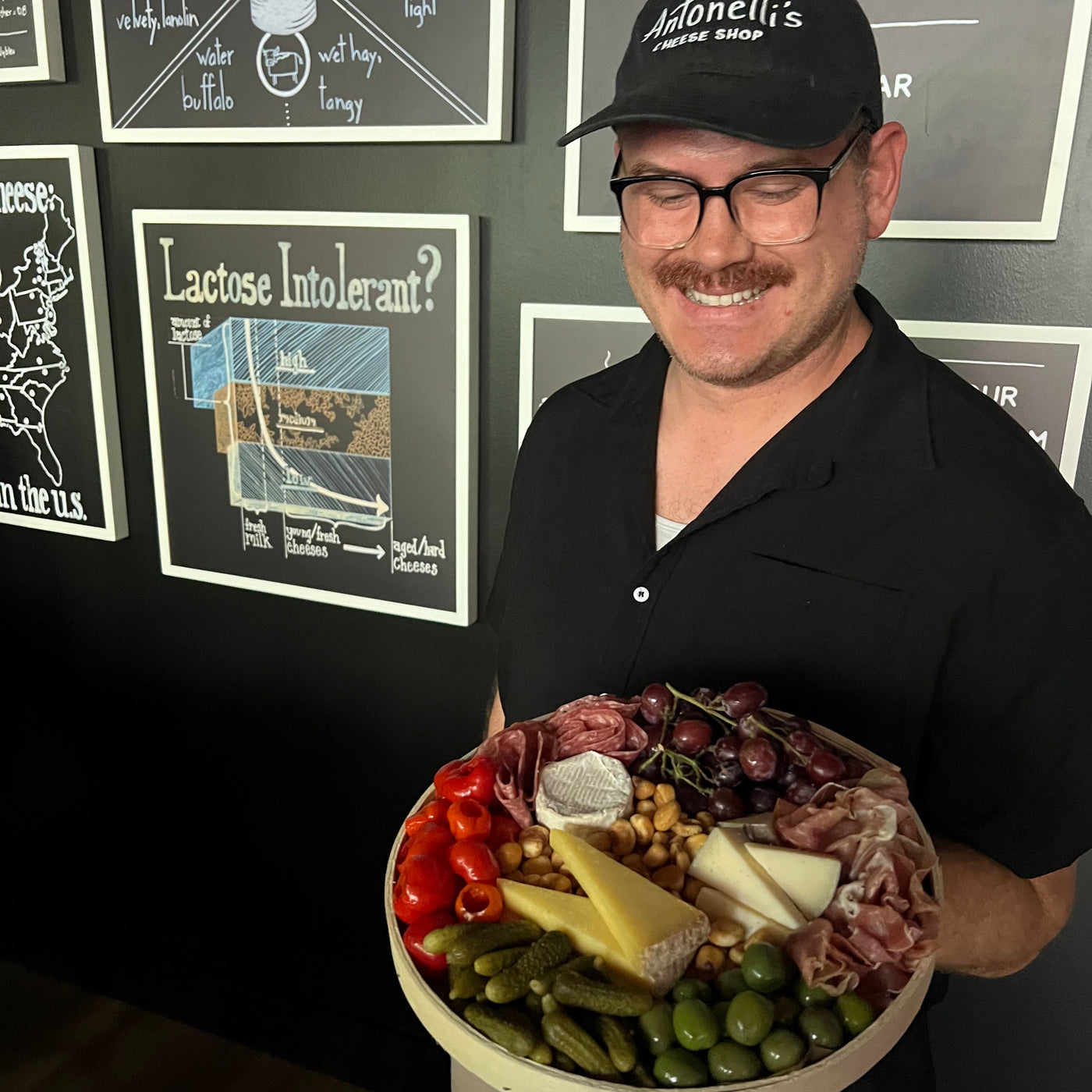 image of a cheesemonger holding a charcuterie board for two