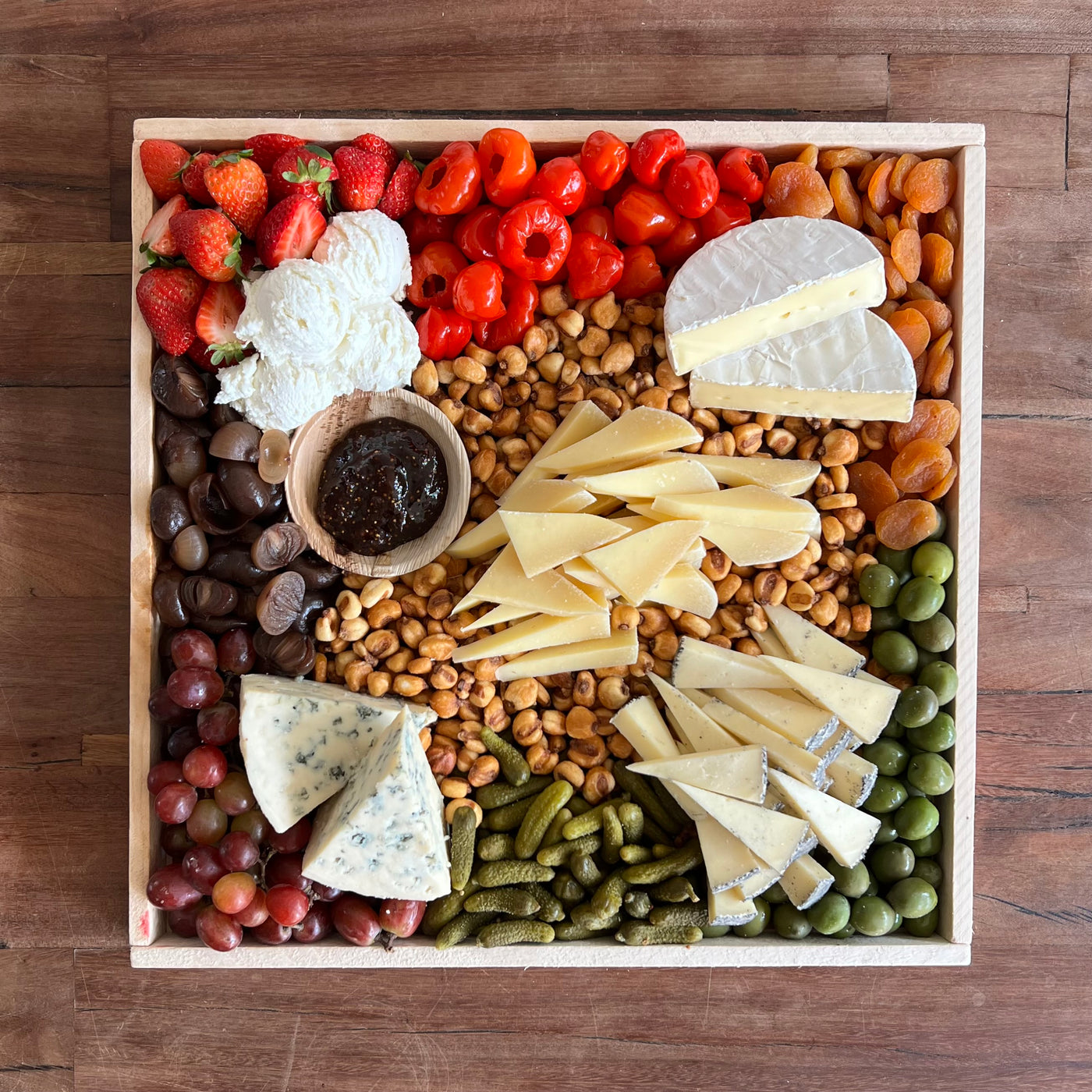 vegetarian cheese board on a picnic table from top view