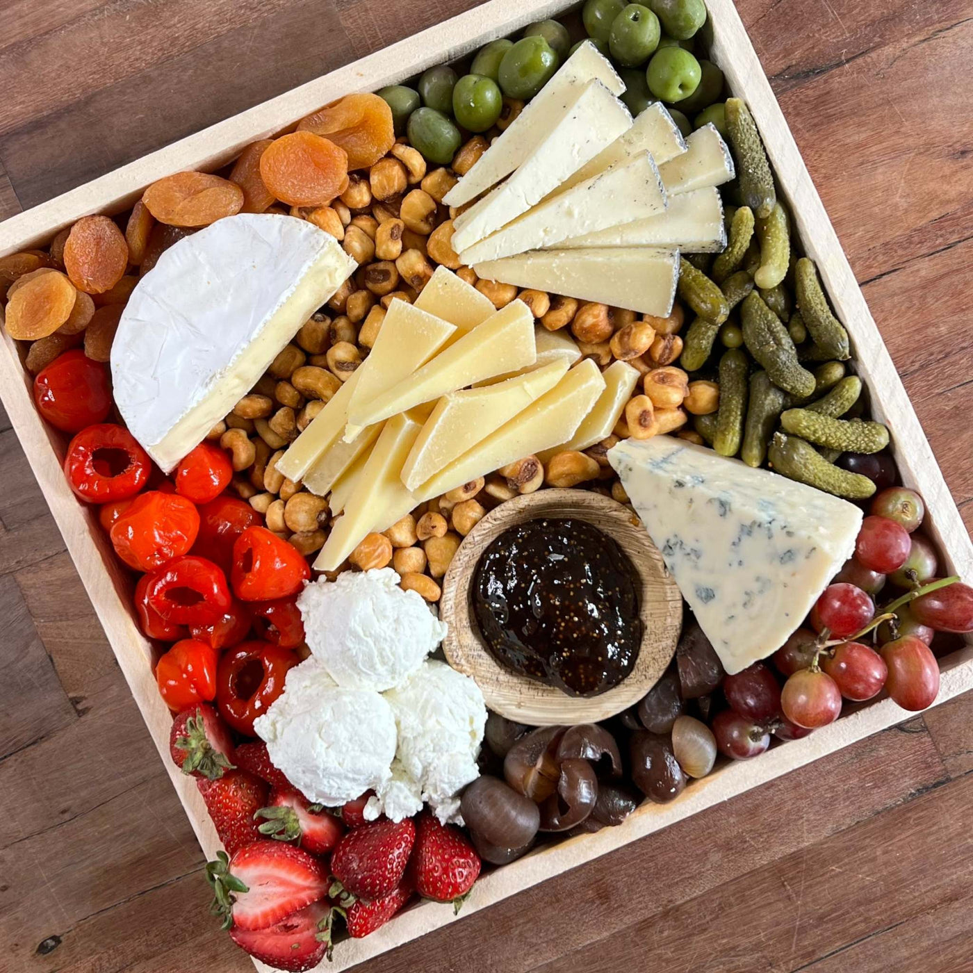 Image of vegetarian cheese board on a picnic table from top view