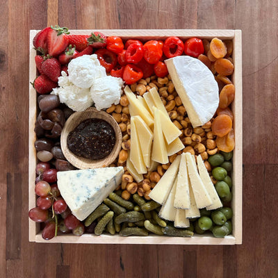 Image of vegetarian cheese board on a picnic table from top view