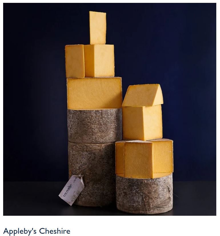 Appleby's Cheshire cheese wheels and blocks stacked against a dark background.