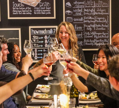 image of customers clinking glasses at Antonelli's cheese tasting