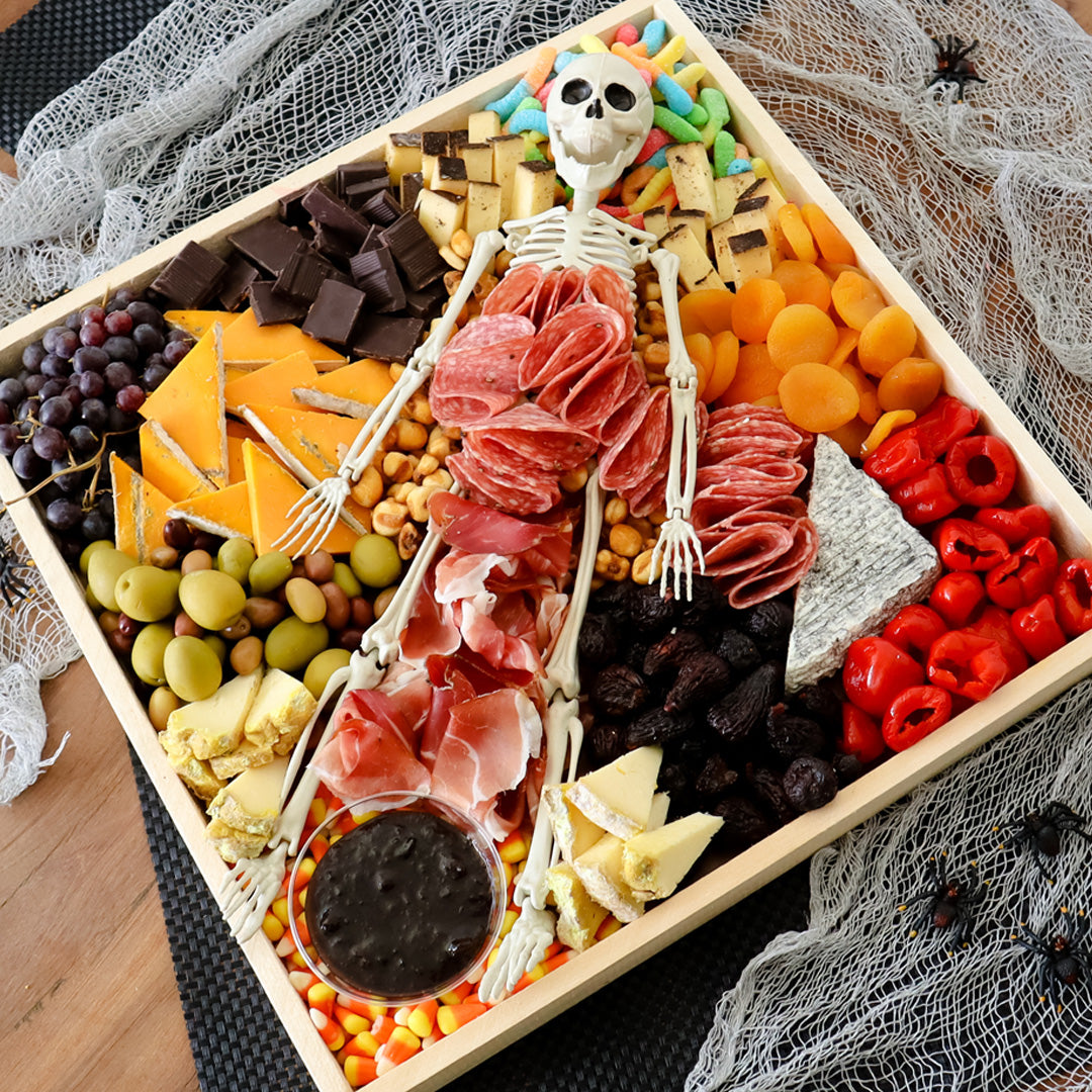 Image of Halloween charcuterie board - Char-Boo-terie with cheese meat and a skeleton